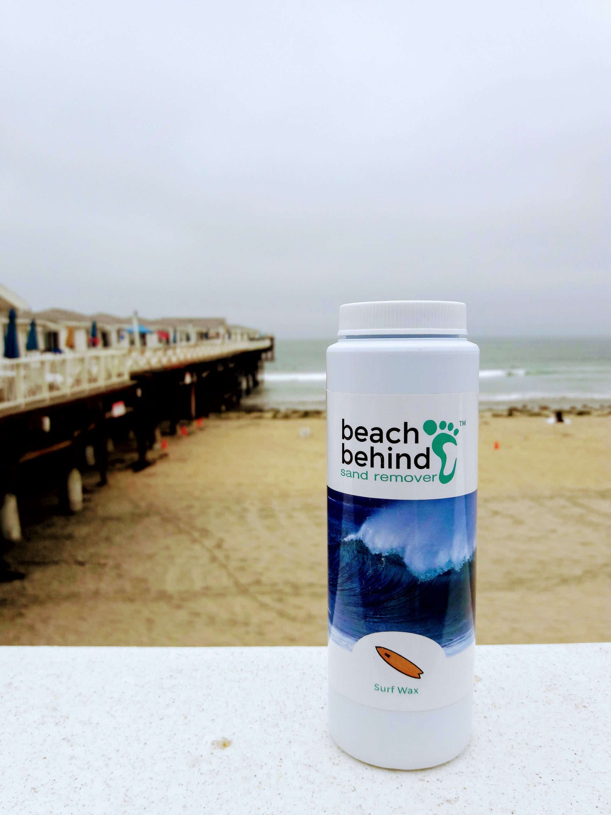 bottle of beach sand remover surfwax scent next to crystal pier in pacific beach ca